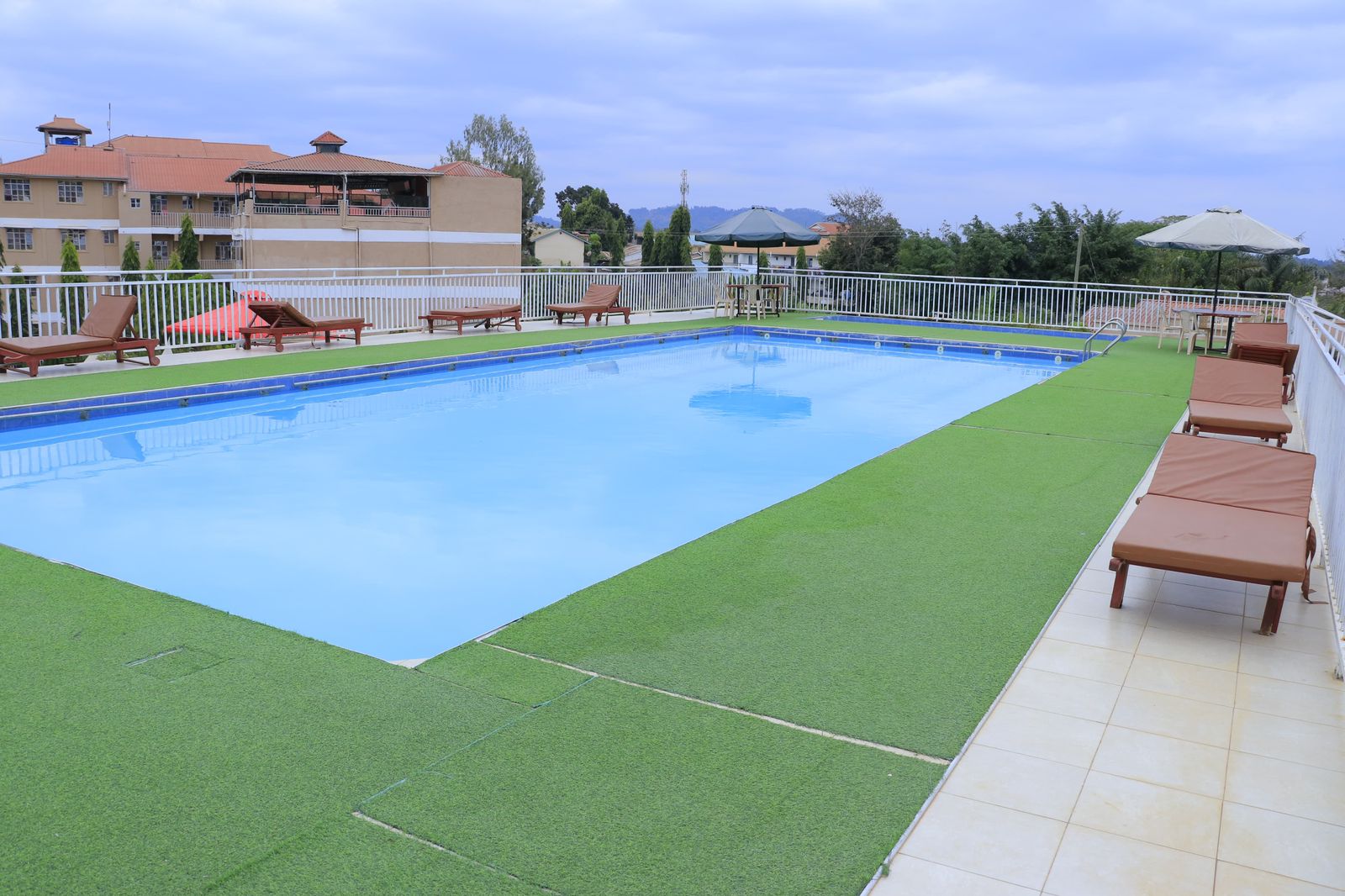 Kitui Premier Resort swimming pool with loungers and beautiful sky